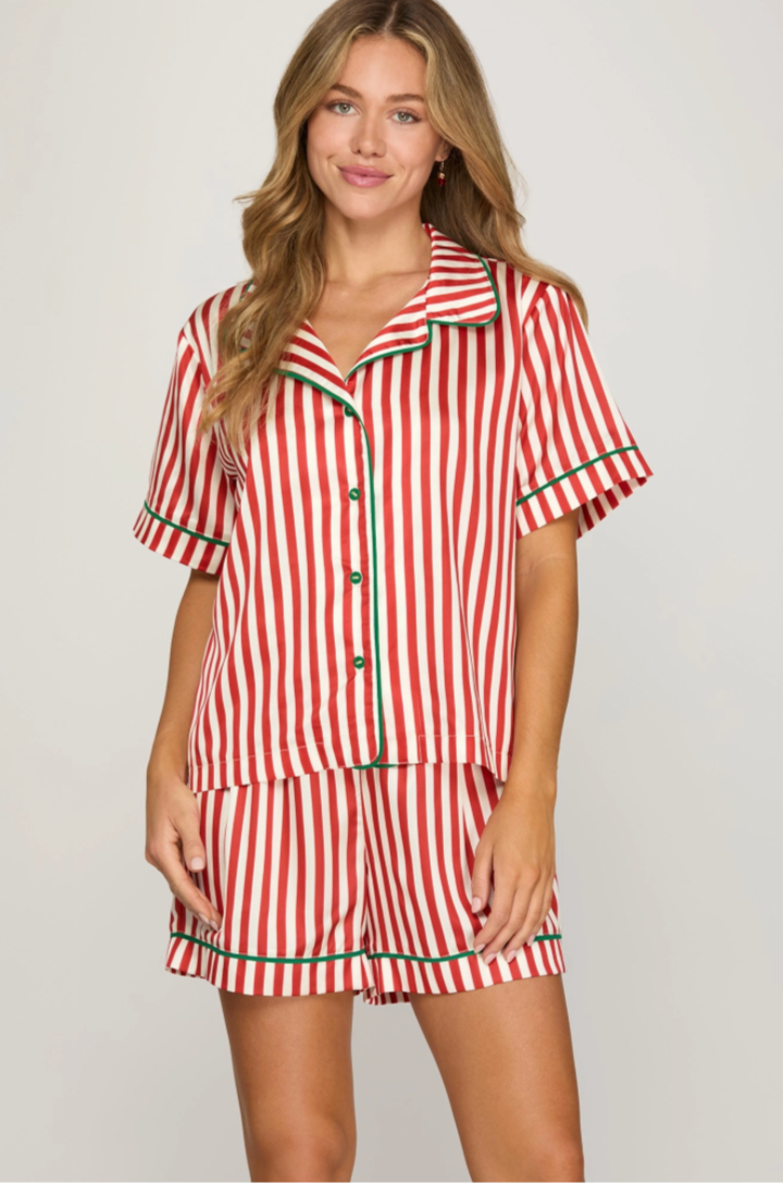 Woman wearing a red and white striped pajama set on a plain background
