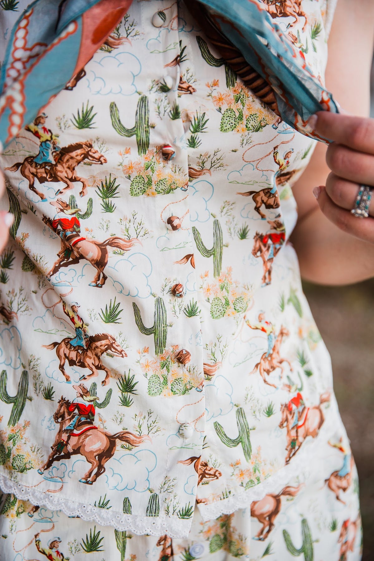 Howdy Hanny sleeveless cowgirl print top with lace trim and button front