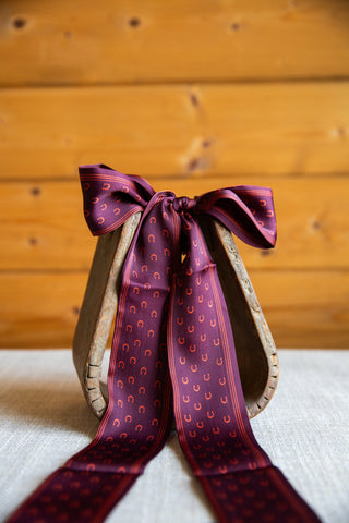 Front view of My Lucky Twilly in Wine by 2 Fly Co, showing small horseshoes and striped borders on a burgundy scarf bow.