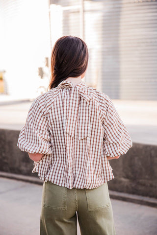 Back view of the Autumn Ridge Plaid Blouse showing the neck bow with long tails, balloon sleeves and rounded hem.