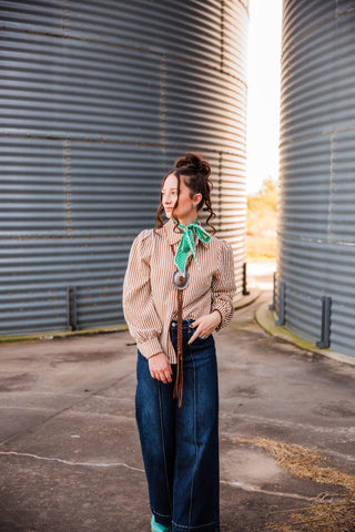Sadie styling the striped Buck Scallop Top with wide-leg dark jeans, a green neck scarf and a long concho necklace.