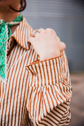 Close-up of the Buck Scallop Top’s striped button cuff, scalloped edging and gathered long sleeve.