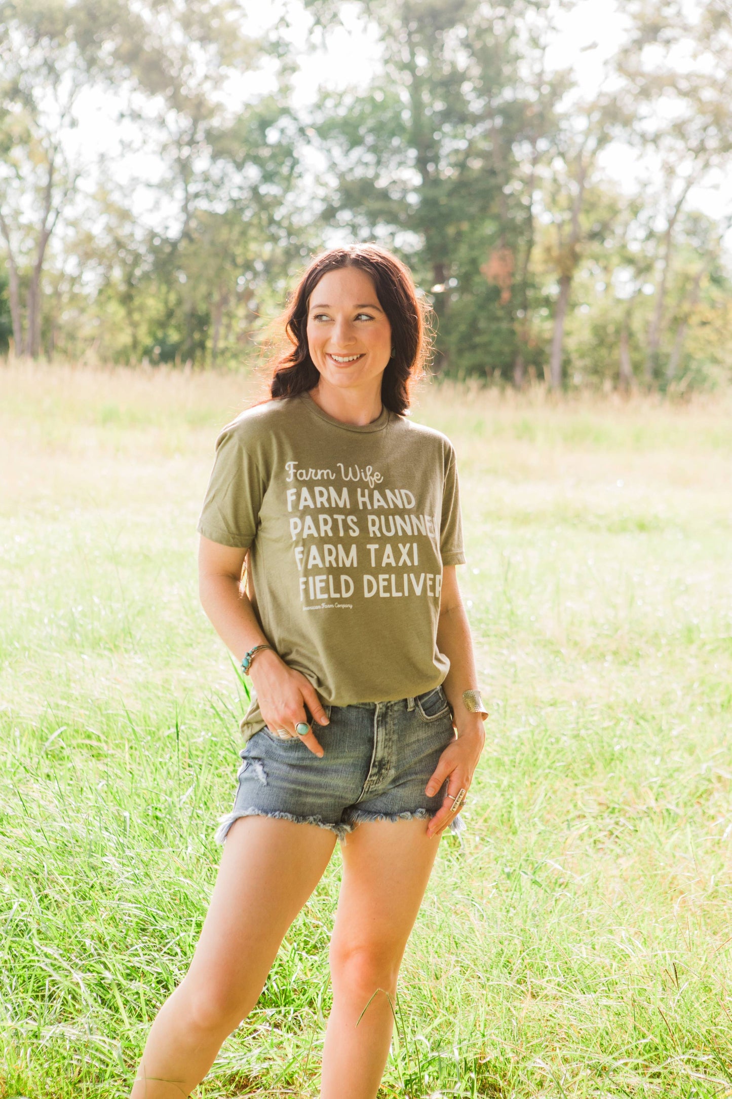 Woman wearing a green t-shirt with text in a field