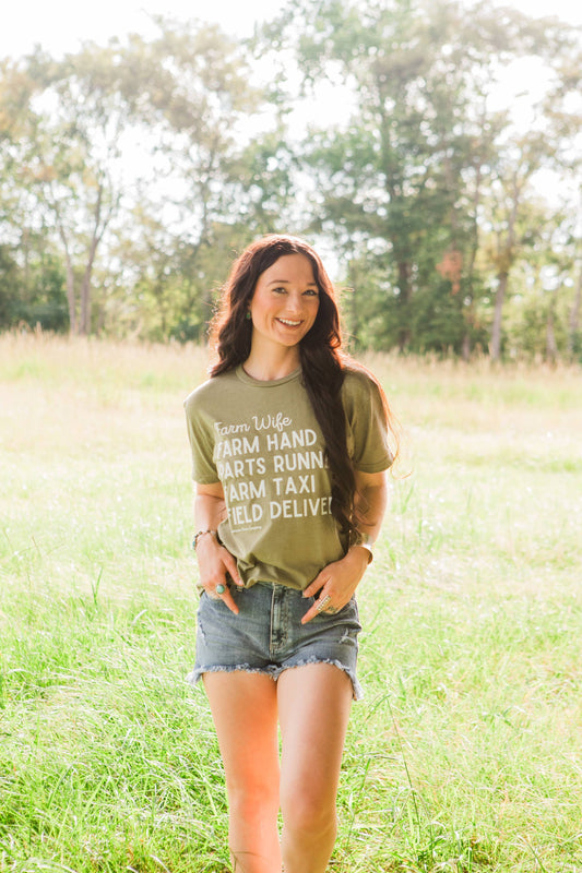 Woman wearing a green t-shirt with text in a field