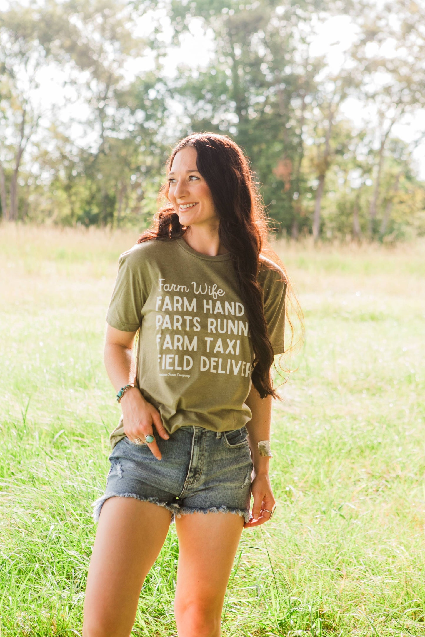 Woman wearing a green t-shirt with text standing in a field
