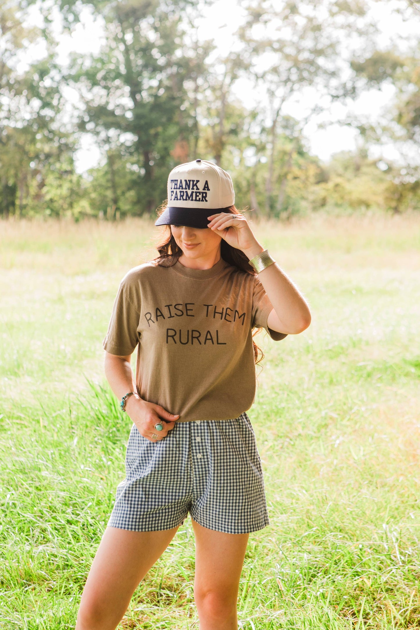 Woman wearing a cap and t-shirt with text in a field