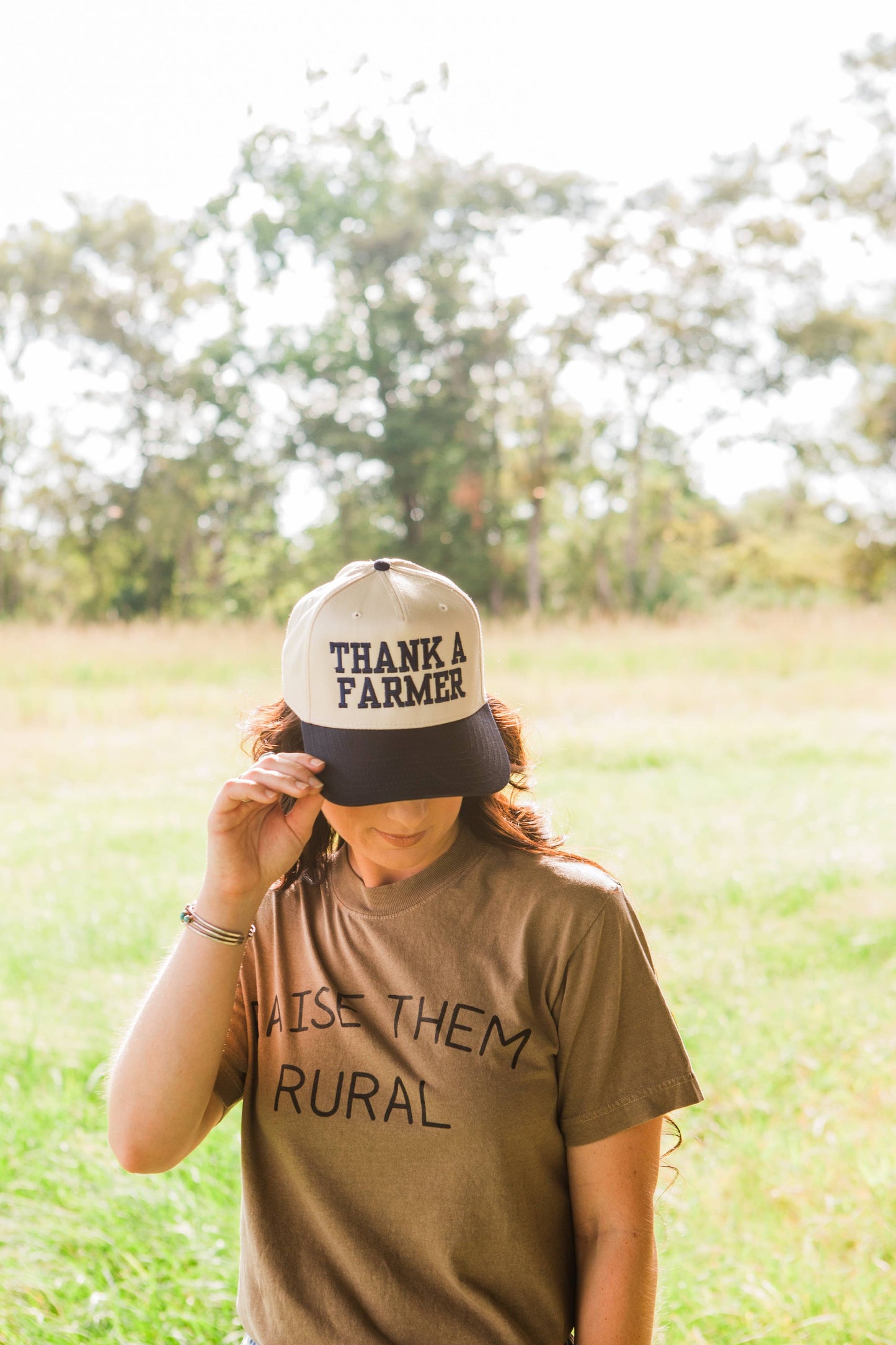Person wearing a cap with 'Thank a Farmer' text in a field