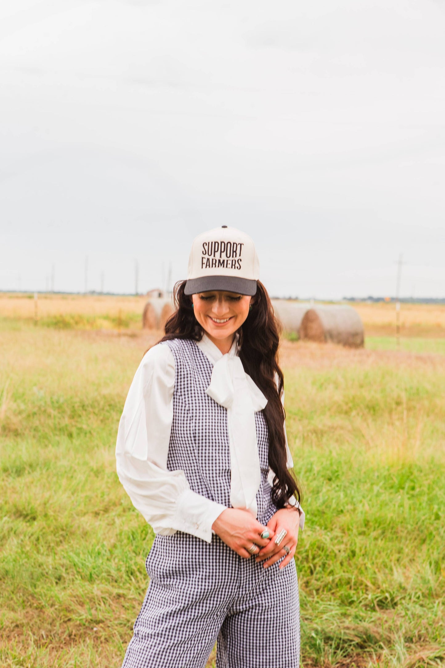 Woman wearing a 'Support Farmers' cap in a field