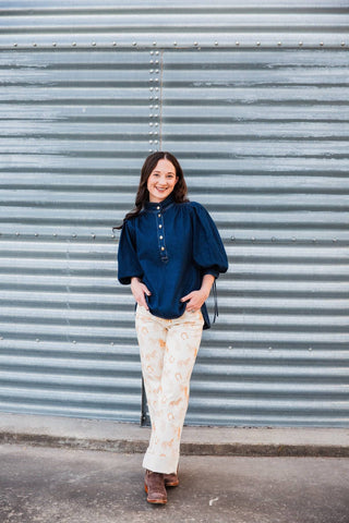 Model wearing the Hadley Denim Top with cream Western-print pants and brown boots in a full-length front view.