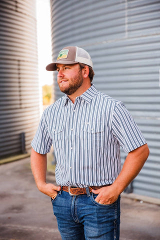 Angled view of Trevor wearing the black-and-white striped Jack in Black pearl snap with short sleeves and flap chest pockets.