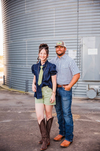 Trevor wearing the striped Jack in Black short-sleeve pearl snap with jeans and brown boots, standing beside Sadie.