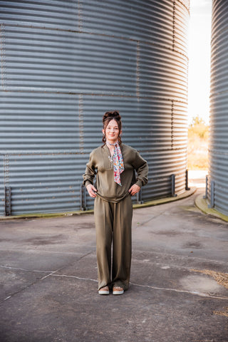 Sadie wearing the olive Weekend Trail Knit Set with a half-zip pullover and wide-leg pants, styled with a scarf and sneakers.