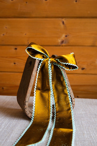 Esther silk twilly by Allie Falcon showing its golden brown patterned fabric, soft sheen and scalloped mint crochet edging.