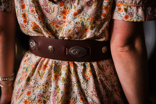 Briar Lee Western concho belt styled over a women’s floral midi dress with cowboy boots