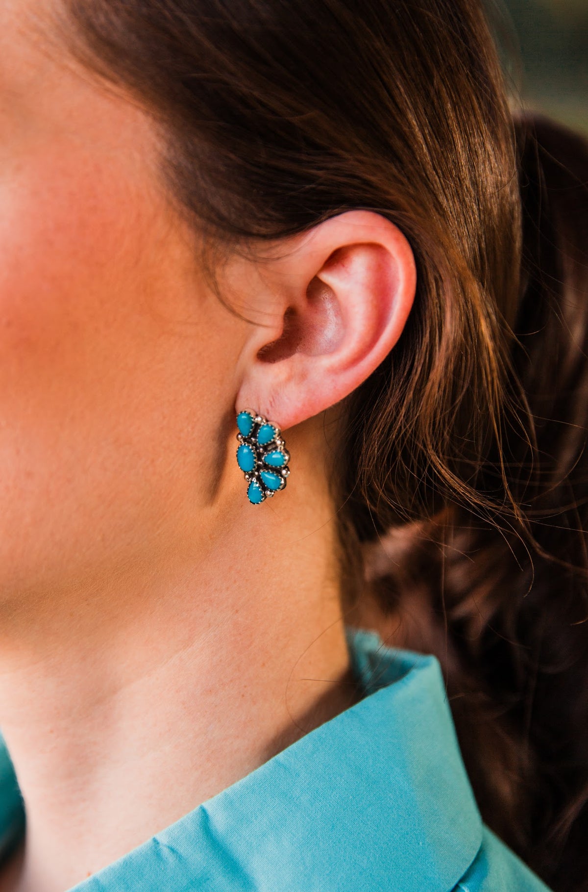 On-ear detail of the Blue Ridge Half Cluster Earring, with blue turquoise stones arranged in a fan-shaped sterling silver setting.