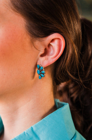 Blue Ridge Half Cluster Earring on a model, showing oval and teardrop turquoise stones with detailed sterling silver borders.