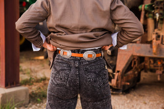 Rear close-up of the Bonnie brown belt with oval silver-tone conchos, radiating stamped lines and rectangular strap openings.