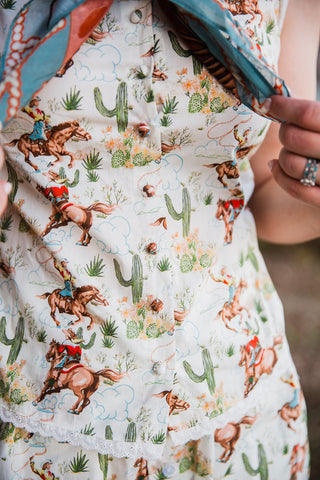 Howdy Hanny sleeveless cowgirl print top with lace trim and button front