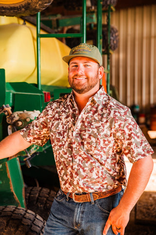 Front view of a model in the Camo Lite short sleeve pearl snap shirt, with a pointed collar and two flap chest pockets.
