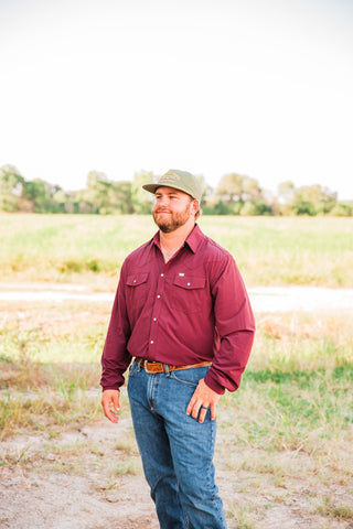 Angled view of the CORE Maroon long sleeve pearl snap shirt, showing its pointed collar and Western chest yokes.