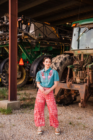 Desert Bandana Western Barrel Jeans in pink paisley styled with a teal embroidered Western shirt and tan sneakers.