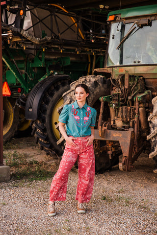 Full-length view of Desert Bandana Western Barrel Jeans with cream bandana motifs, worn with a tucked-in teal shirt.