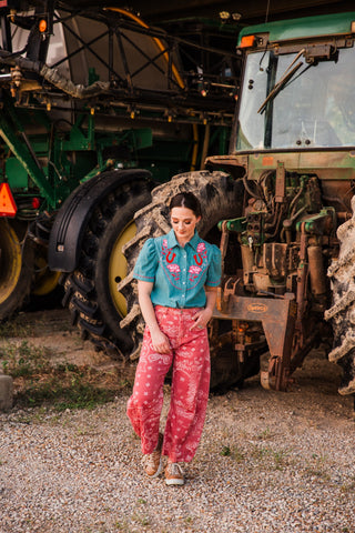 Model walking in Desert Bandana Western Barrel Jeans, showing the curved pink paisley legs styled with tan sneakers.