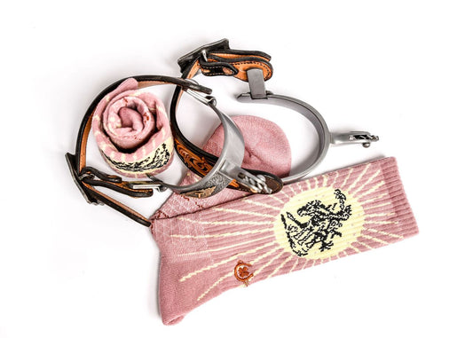 Decorative spur with pink fabric, rose, and decorative box on a white background