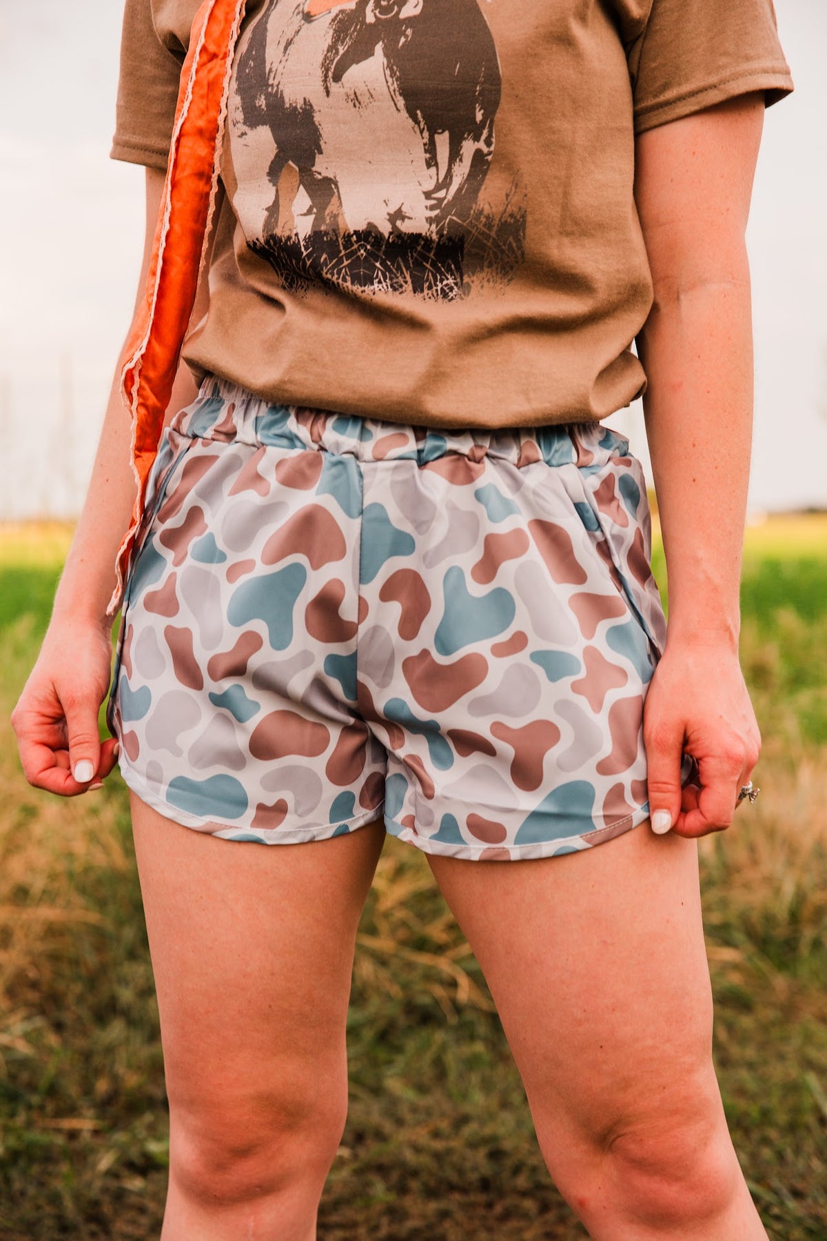 Front detail of Old School women’s camo shorts by Front Porch Label, showing a gathered waistband and muted blue, brown and gray print.