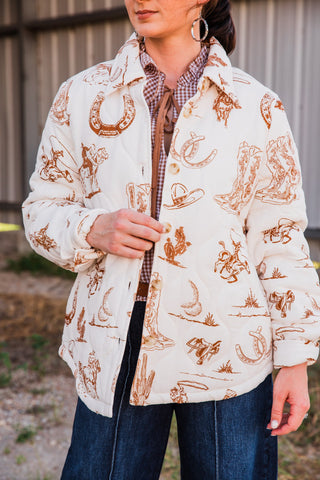 Frontier Jacket print close-up with brown cowboy boots, hats, horseshoes, cacti and roping riders on a cream background.