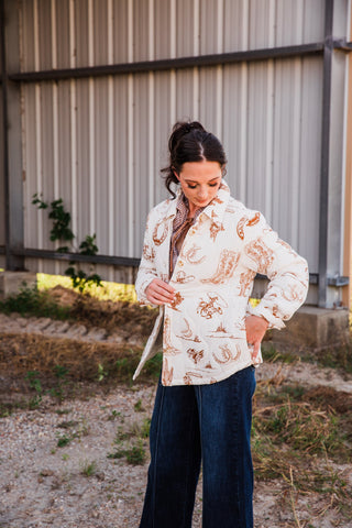 Angled view of the Frontier Jacket on a model, showing its hip-length cut, long sleeves and brown Western print on cream.