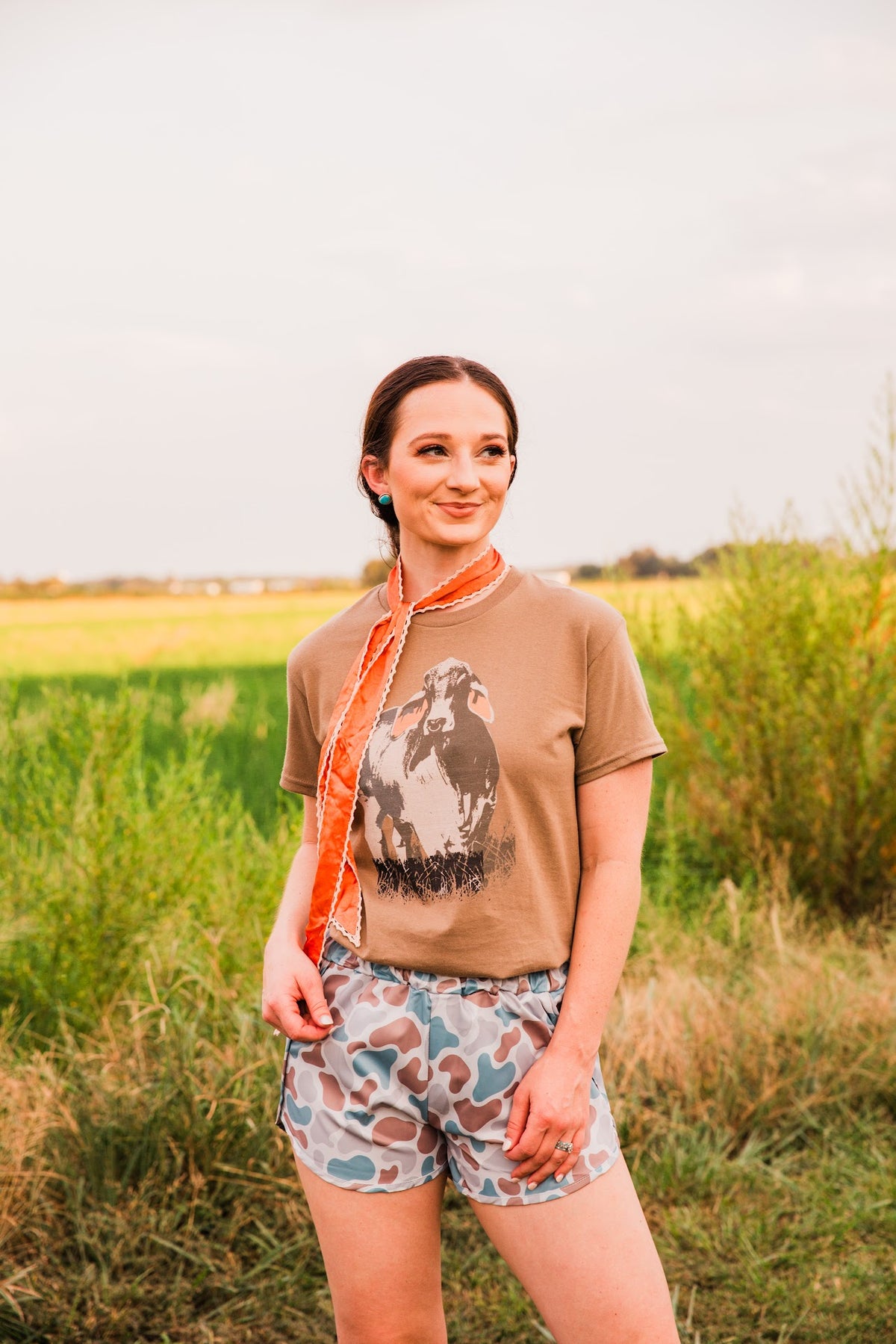 Vintage Brahman Bull Tee by Hank & Scoot styled outdoors with muted camo shorts and a long orange scarf for a casual Western outfit.