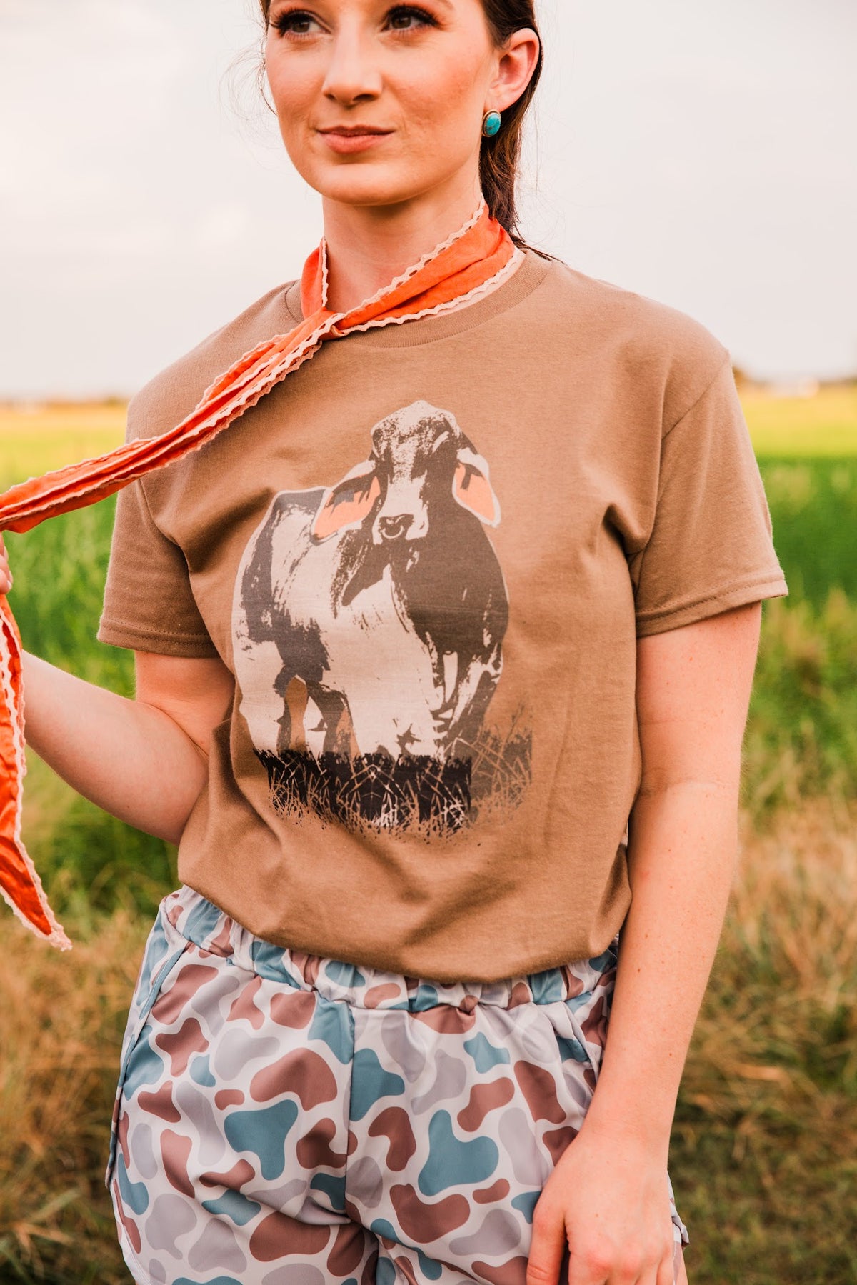 Close-up of the Vintage Brahman Bull Tee showing the distressed bull illustration on brown fabric, tucked into camo shorts.