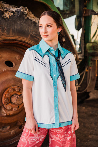 Hold Your Horses black Twilly tied beneath a turquoise shirt collar, showing its narrow shape and pointed patterned ends.