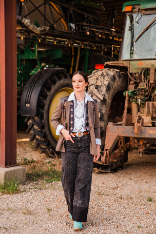 Honey Black Stone wide-leg jeans with dark wide cuffs, styled with a brown blazer, white blouse and turquoise boots.