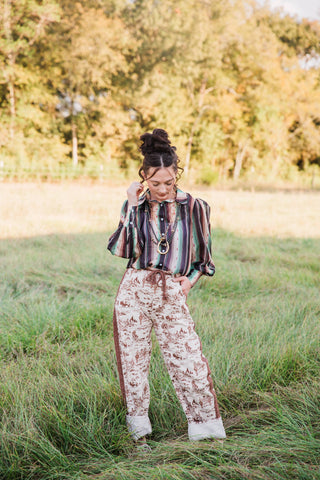 Howdy Hanny Ranch Life Barrel Jeans with brown ranch print on cream denim, styled with a striped blouse and rolled cuffs.