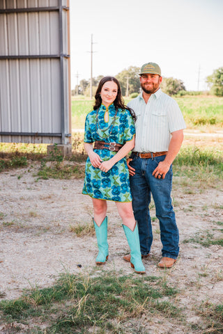 Model in the Jack in Green short sleeve pearl snap shirt, jeans and boots beside a woman in a blue floral dress.