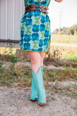 Lissie Mini Dress in size S/M on Sadie, showing the blue floral skirt, yellow-trimmed mini hem, and turquoise cowboy boots.