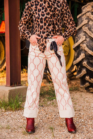 Front view of Sadie in Extra Small Lucky Babe Pants, showing the red geometric pattern, front pockets, and wide turned-up cuffs.