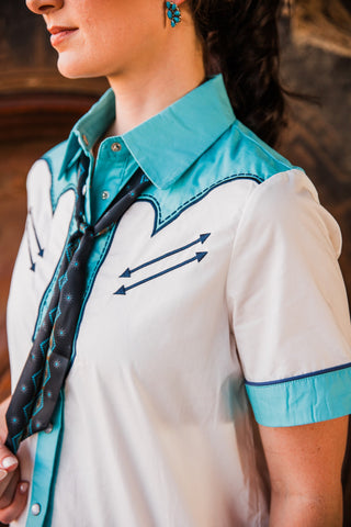Old School Puncher Pearl Snap close-up showing navy embroidered arrows, a turquoise Western yoke and matching sleeve trim.