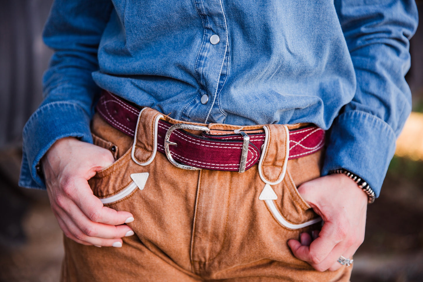 Close-up of Polly Tan Western denim shorts featuring contrast piping and wide belt loops by howdy hanny