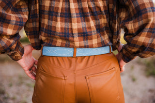 Back view of the Powder Blue Suede Belt showing white figure-eight gunslinger stitching above caramel pants pockets.