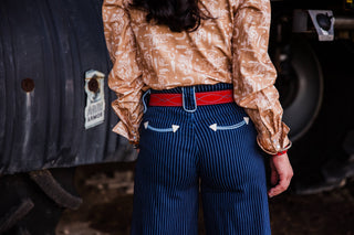 Women’s red suede cowgirl belt with turquoise contrast stitching styled with dark pinstripe jeans by double j saddlery