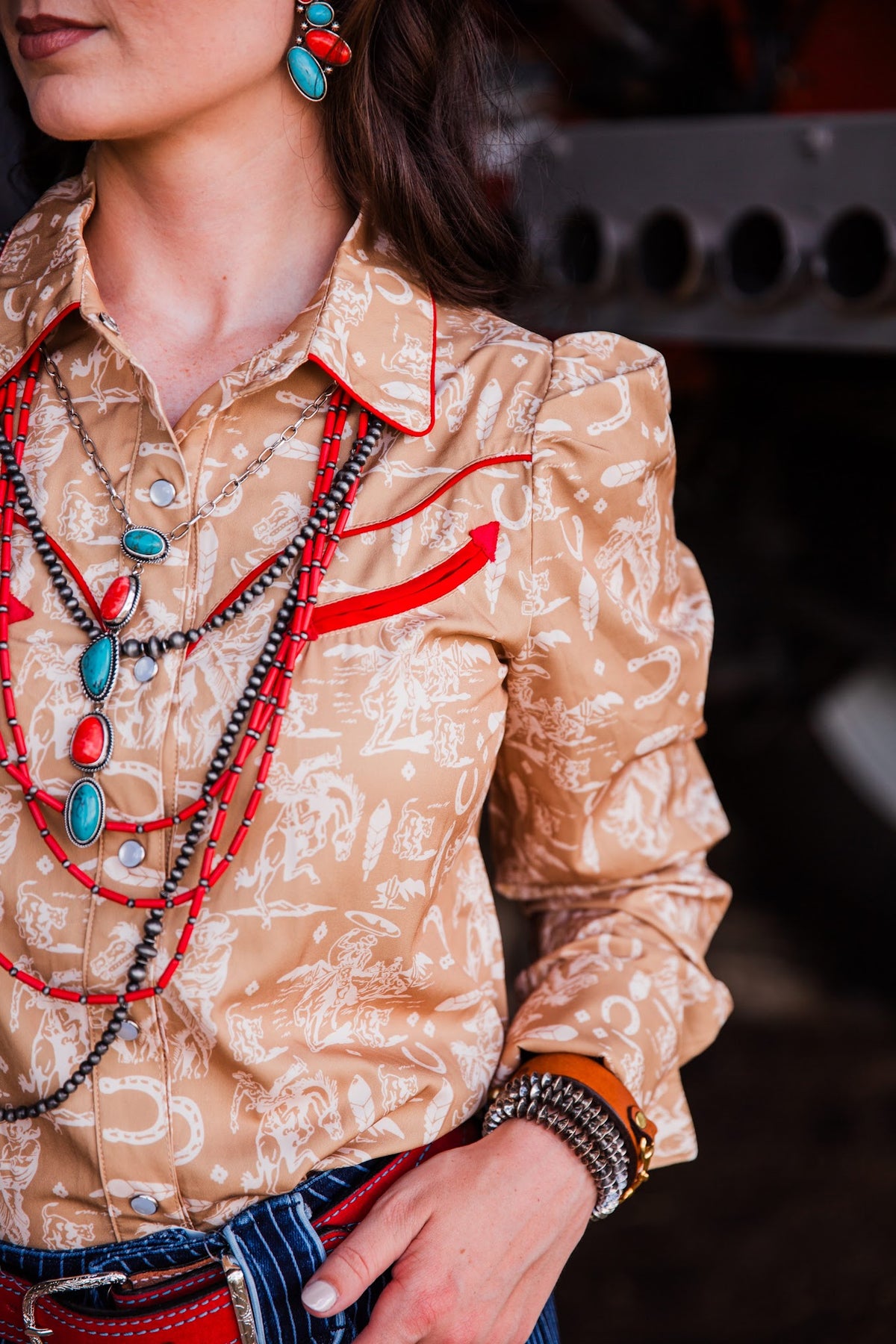 Women’s tan pearl snap Western shirt with cream cowboy print, red accents and statement sleeves