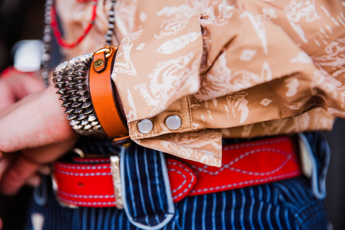Close-up of women’s cowboy toile pearl snap shirt showing red piping and pearl snap cuff details
