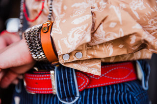Close-up of women’s cowboy toile pearl snap shirt showing red piping and pearl snap cuff details