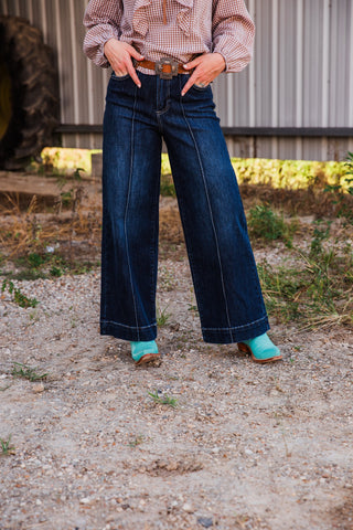 Closer front view of Sammy dark wash wide-leg jeans, showing high-rise waist, front pockets and long contrast-stitched seams.