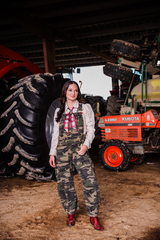 Shawnee women’s camo barrel overalls with relaxed barrel leg fit styled with Western pearl snap shirt
