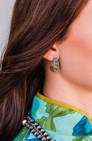 Close-up of a Sonoran Trail #2 hoop earring worn on the ear, showing green turquoise stones and twisted silver rope detailing.