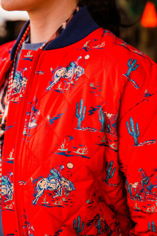 Southern Cowboy Bomber Jacket detail showing the navy ribbed collar, red front zipper and quilted horseback rider and cactus print.